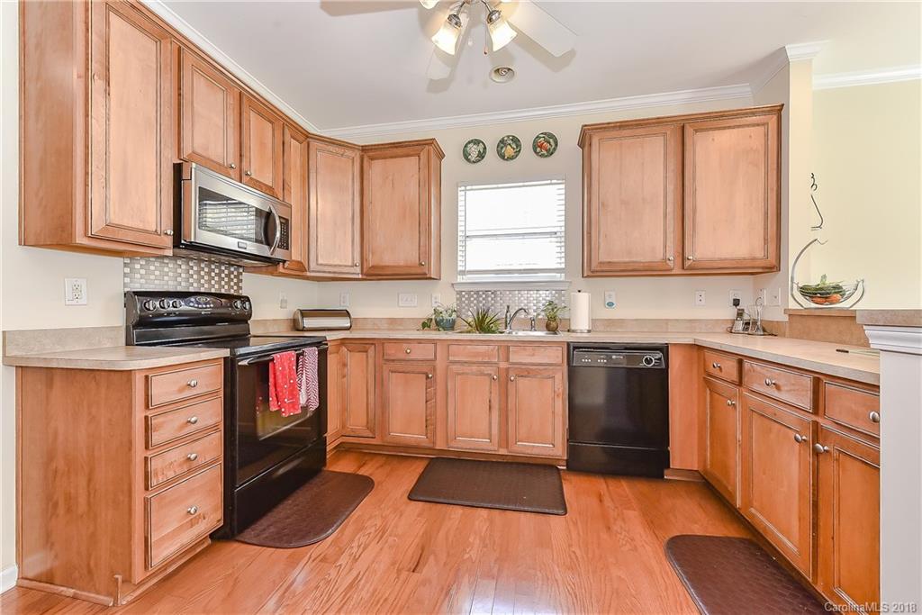 325 Sand Paver Way, Unit 99 Fort Mill, SC 29708 - Photo 12 of 25 a kitchen with stainless steel appliances granite countertop a stove a sink and a microwave