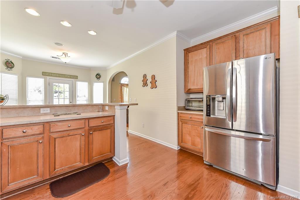 325 Sand Paver Way, Unit 99 Fort Mill, SC 29708 - Photo 14 of 25 a kitchen with granite countertop stainless steel appliances a refrigerator cabinets and wooden floor