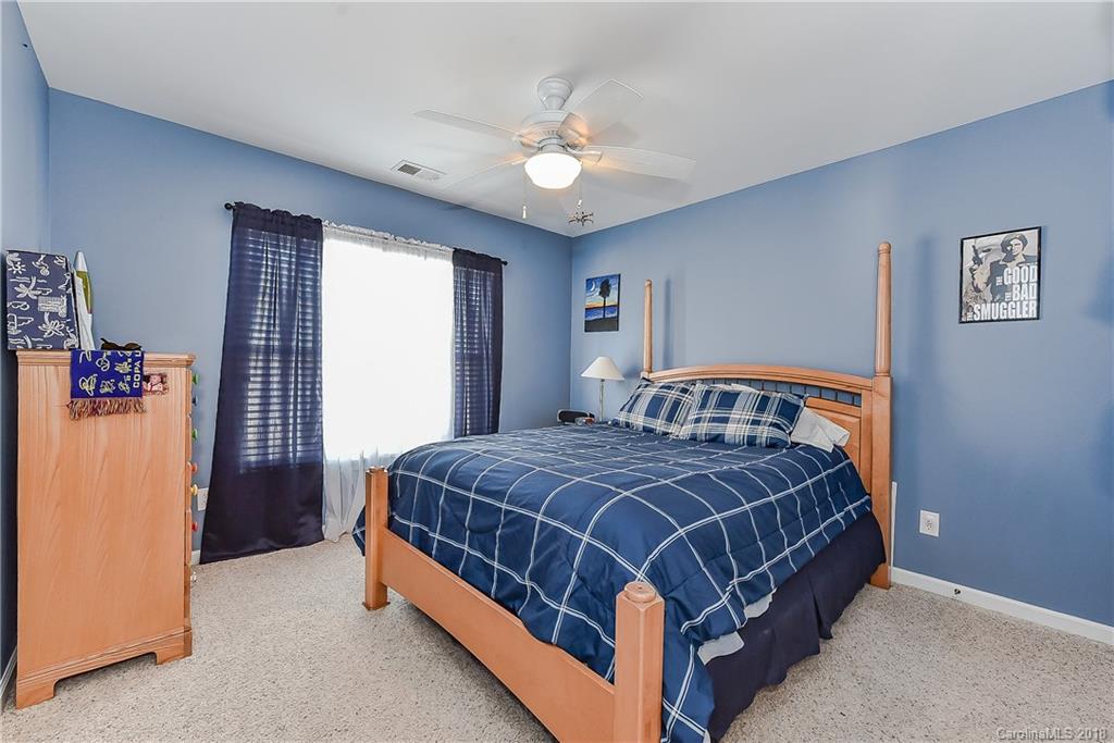 325 Sand Paver Way, Unit 99 Fort Mill, SC 29708 - Photo 21 of 25 a bedroom with a bed and a chandelier