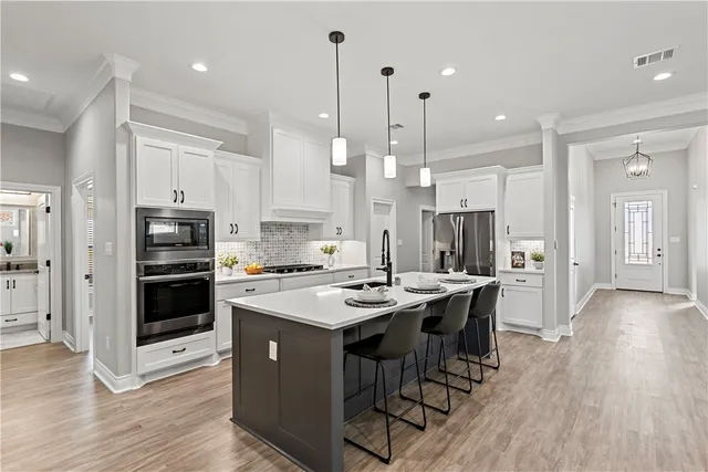 a kitchen with kitchen island a stove a sink and a fireplace with wooden floor