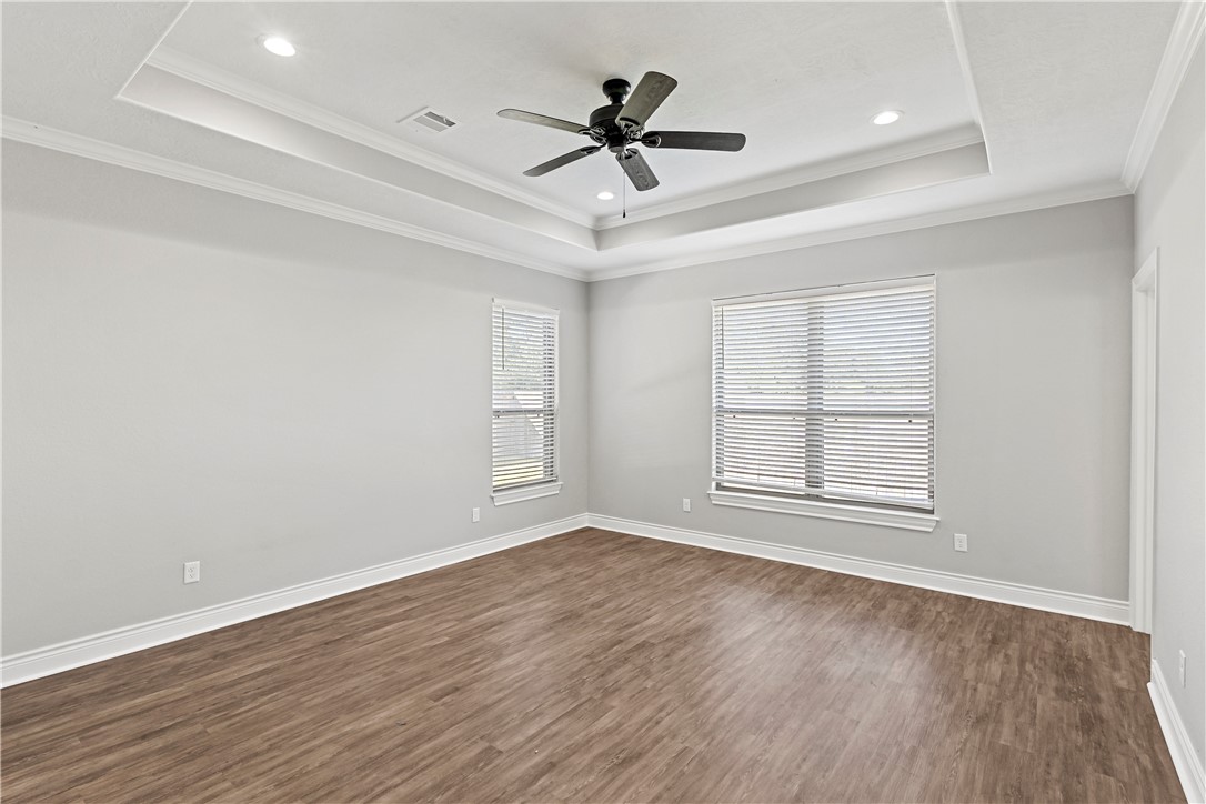 2912 GOLDBERG Drive Bryan, TX 77808 - Photo 26 of 35 an empty room with wooden floor ceiling fan and windows