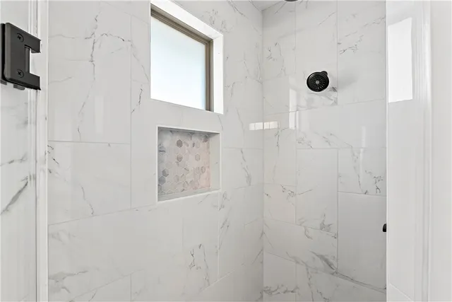a white bath tub sitting next to a shower