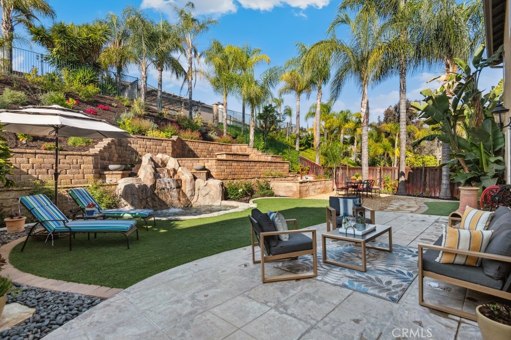 a view of a swimming pool with lawn chairs under an umbrella