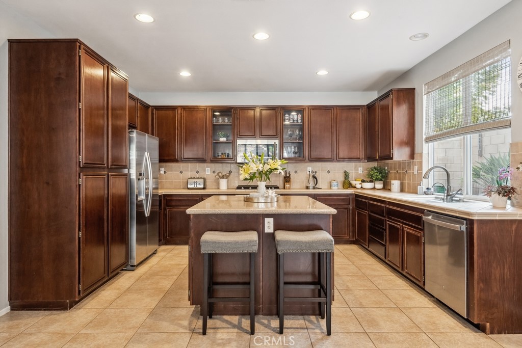 38790 Cobblestone Circle Murrieta, CA 92563 - Photo 18 of 43 a kitchen with stainless steel appliances granite countertop a refrigerator a sink a stove a dining table and chairs