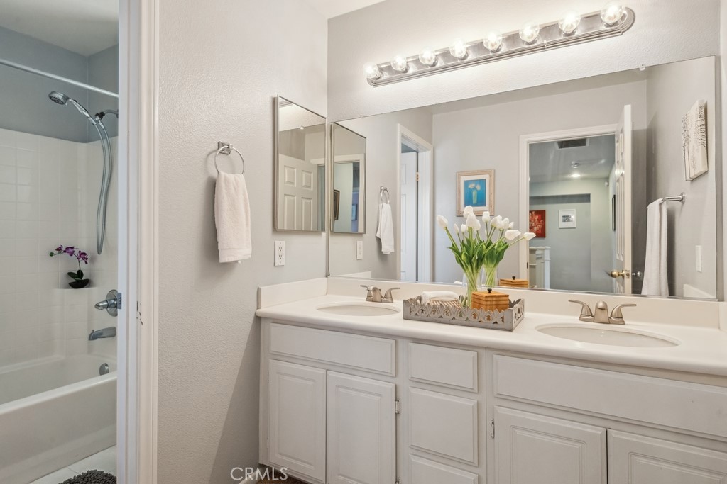 38790 Cobblestone Circle Murrieta, CA 92563 - Photo 31 of 43 a bathroom with a double vanity sink a mirror a bathtub and shower