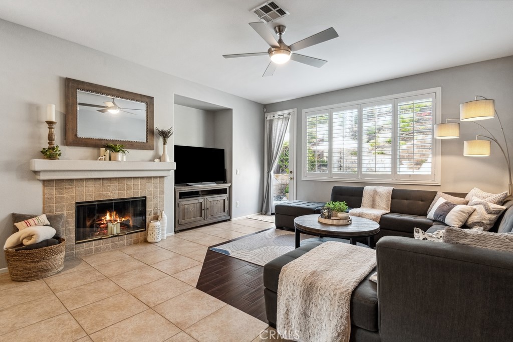 38790 Cobblestone Circle Murrieta, CA 92563 - Photo 9 of 43 a living room with furniture a fireplace and a flat screen tv