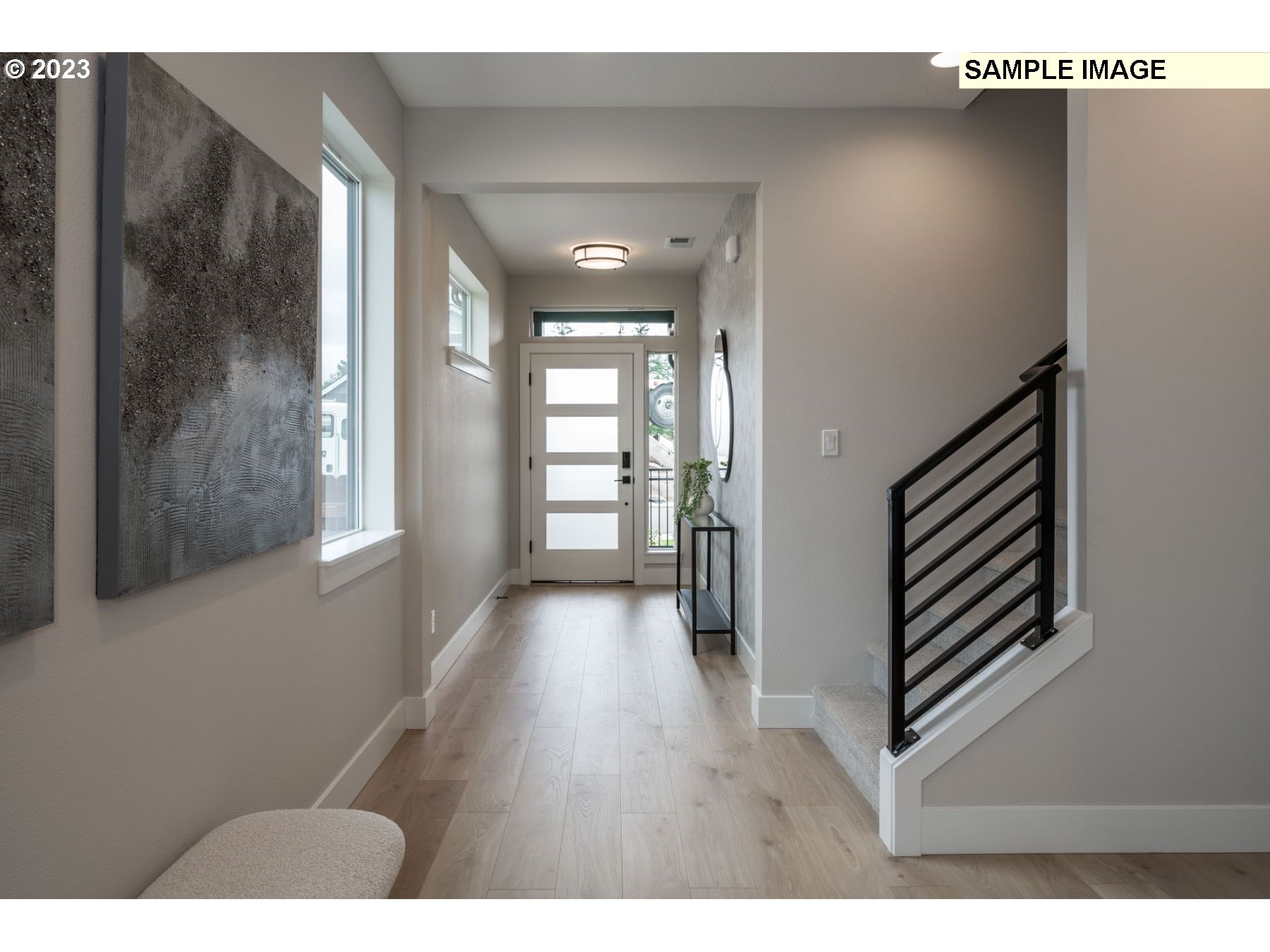 1121 South 46th Place Ridgefield, WA 98642 - Photo 3 of 18 a hallway with wooden floor chandelier and windows