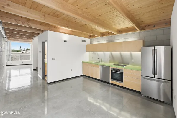 a kitchen with stainless steel appliances kitchen island granite countertop a refrigerator and a stove