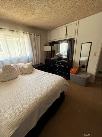 a bedroom with a bed a couch and large mirror