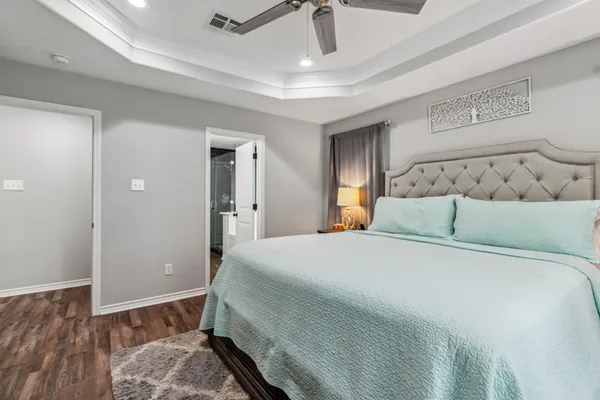a bedroom with a bed and wooden floor