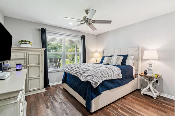 a bedroom with a bed and a flat tv screen on the dresser