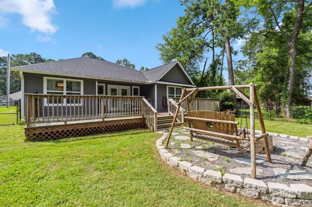 a white house with a small yard and large trees