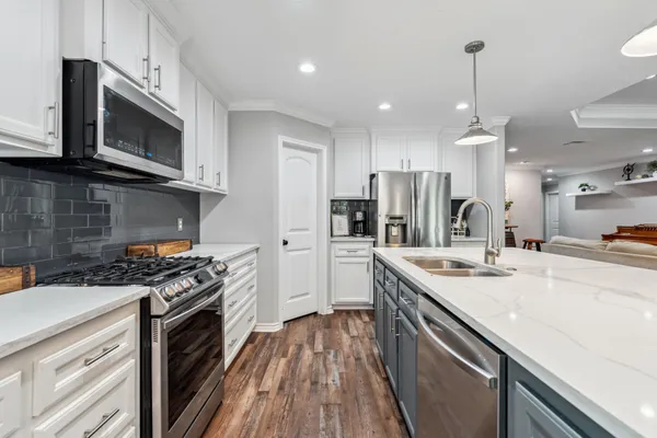 a kitchen with stainless steel appliances a sink stove and refrigerator
