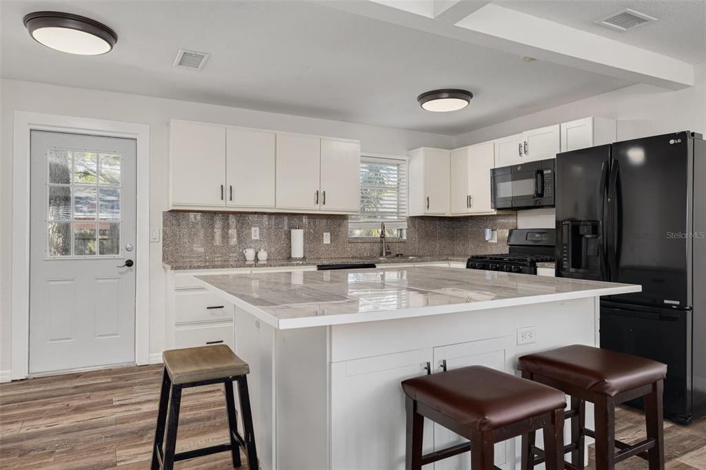 200 Broadway Dunedin, FL 34698 - Photo 12 of 59 a kitchen with stainless steel appliances a stove a sink island and a refrigerator