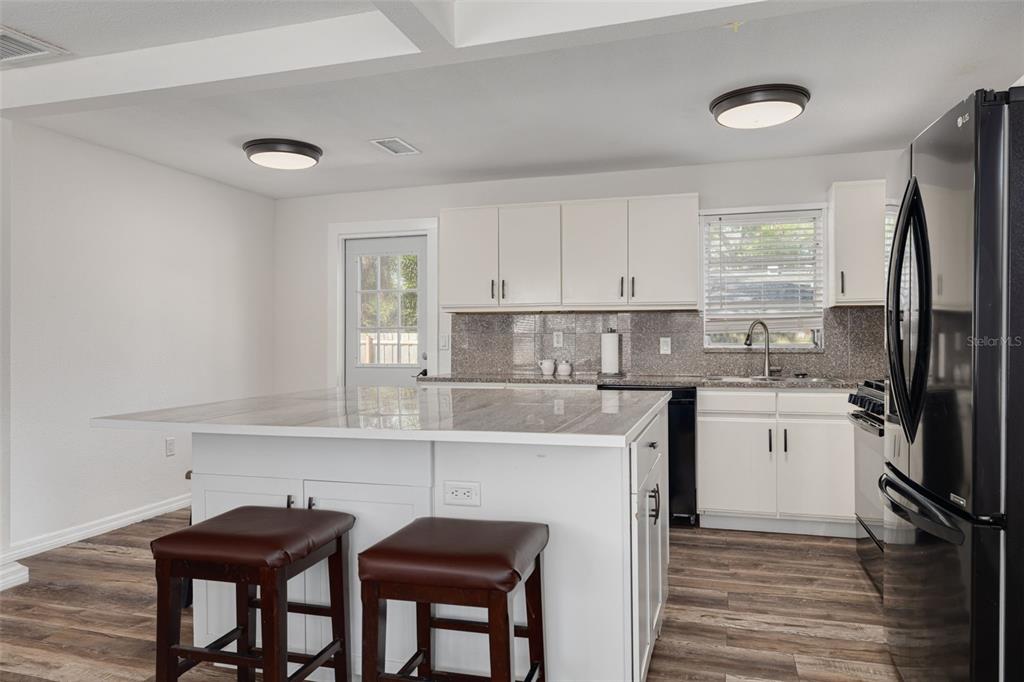 200 Broadway Dunedin, FL 34698 - Photo 13 of 59 a kitchen with stainless steel appliances a stove a sink refrigerator and cabinets