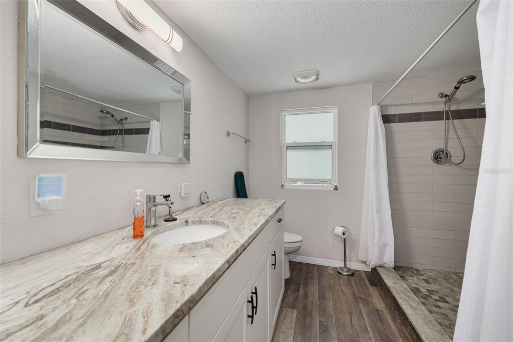 200 Broadway Dunedin, FL 34698 - Photo 21 of 59 a bathroom with a granite countertop sink toilet and shower