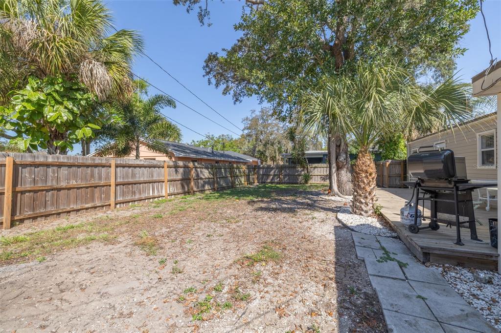 200 Broadway Dunedin, FL 34698 - Photo 27 of 59 a view of a backyard with table and chairs and a large tree