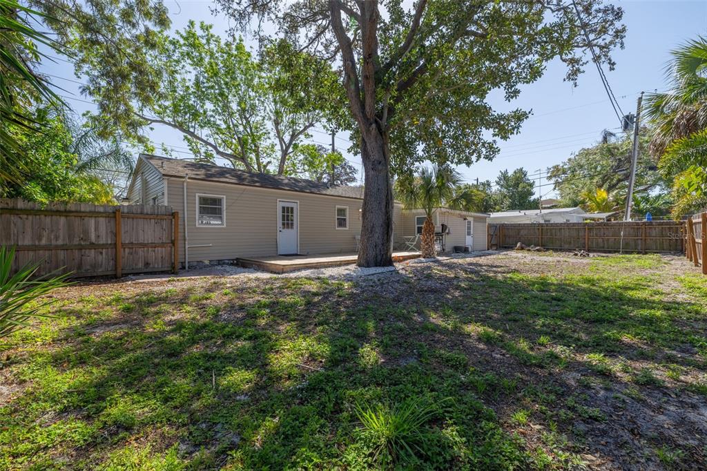 200 Broadway Dunedin, FL 34698 - Photo 28 of 59 a view of a backyard with large trees and wooden fence
