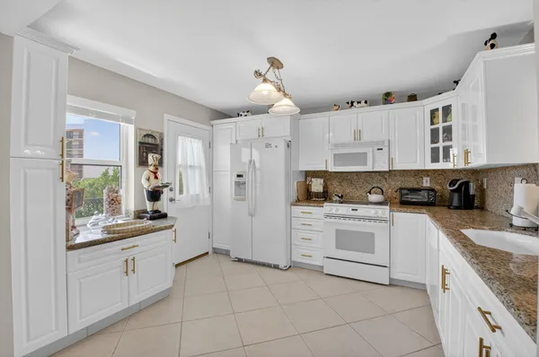 a kitchen with white cabinets and white appliances