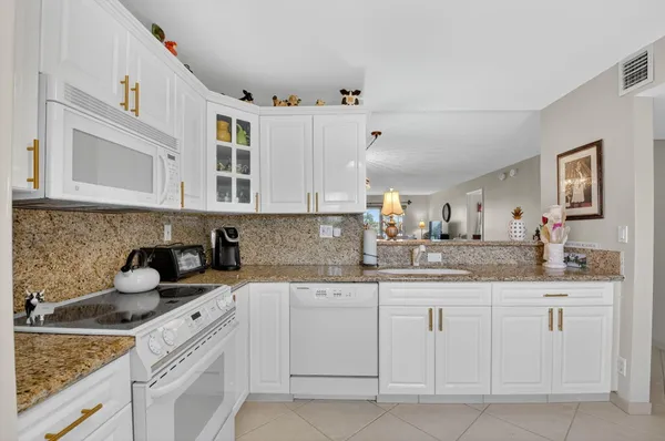 a kitchen with white cabinets and white appliances