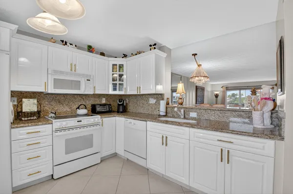 a kitchen with white cabinets and window