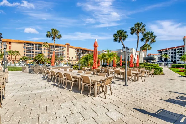 a view of a patio with a dining table chairs and iron fence