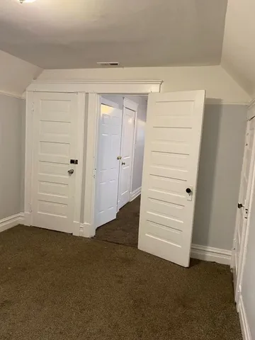 an empty room with a hallway and stairs