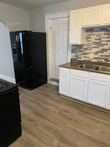a kitchen with granite countertop white cabinets and refrigerator