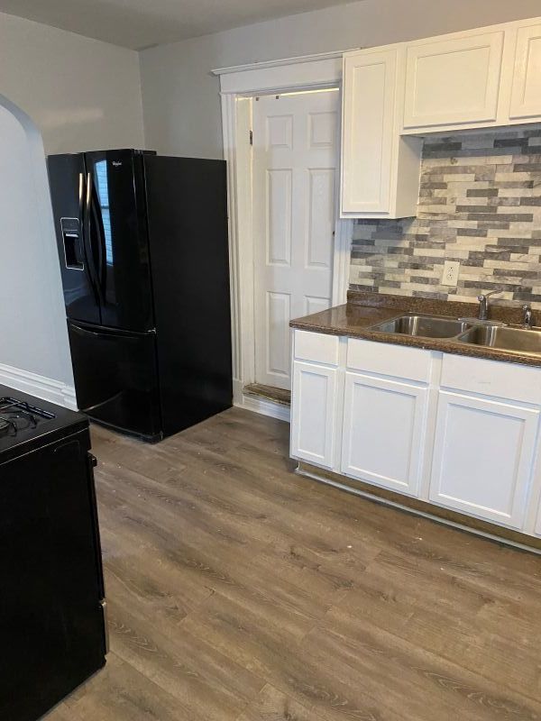 1340 East 76th Street, Unit 2 Chicago, IL 60619 - Photo 5 of 10 a kitchen with granite countertop white cabinets and refrigerator