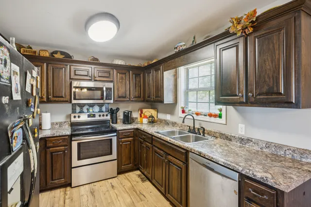 a kitchen with stainless steel appliances granite countertop a stove sink and cabinets