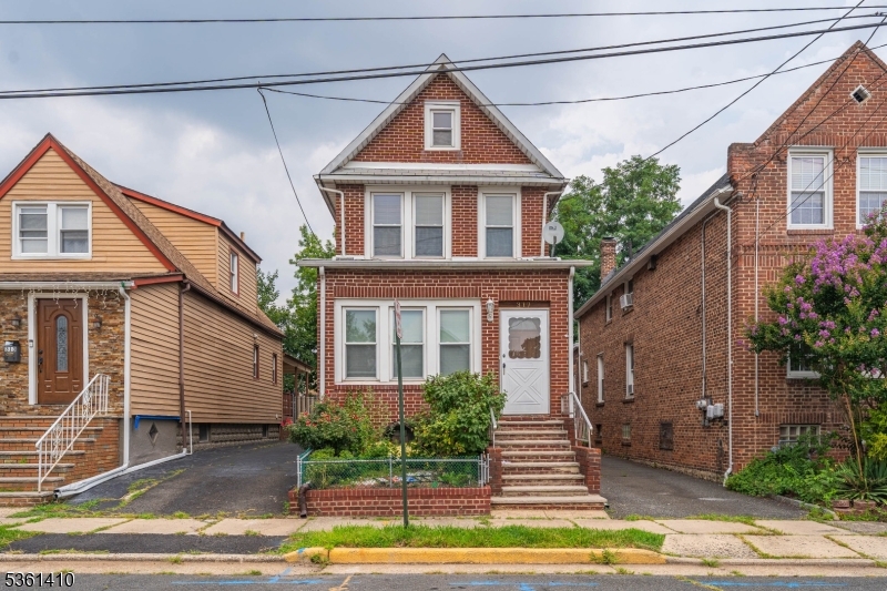 a front view of a house with a yard and potted plants
