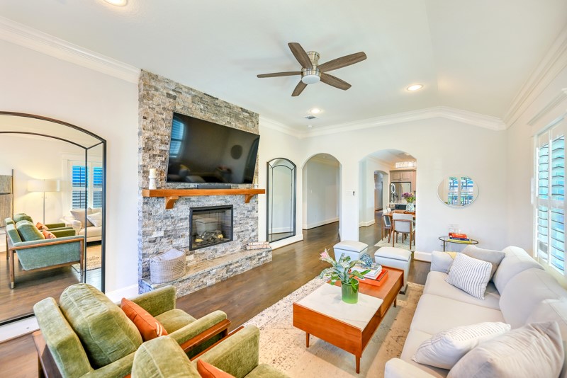 1122 East 23rd Street Houston, TX 77009 - Photo 6 of 23 Inviting living room with a beautiful stone fireplace, warm wood floors, and an open-concept design perfect for everyday living and entertaining.