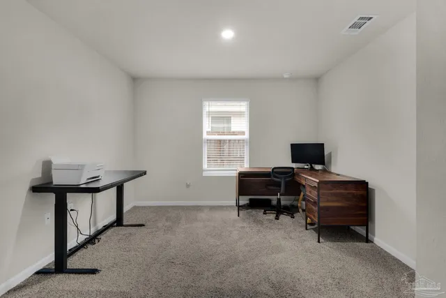 a view of a workspace with furniture and a window