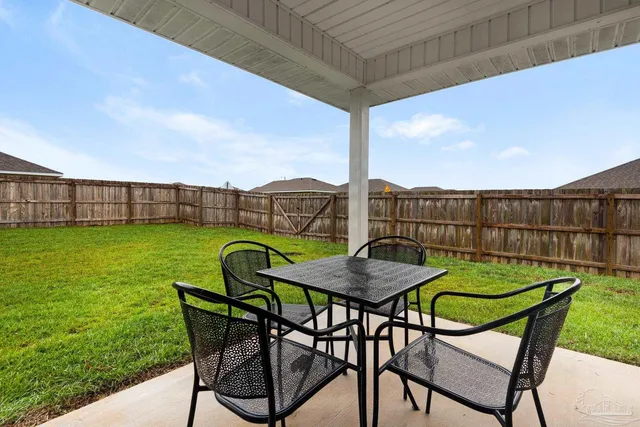 a backyard of a house with table and chairs