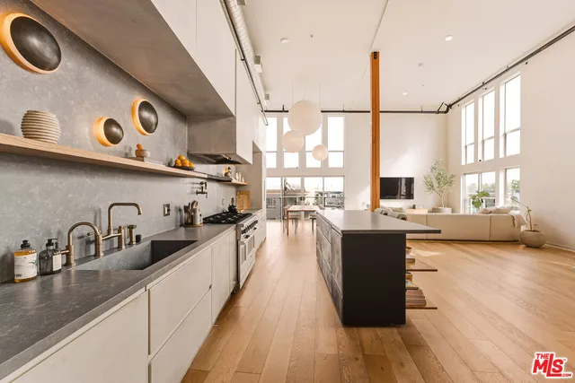 a view of a kitchen with kitchen island a large window a sink and counter top space