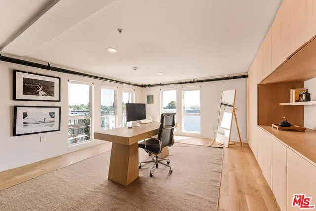 a view of a livingroom with workspace and a window