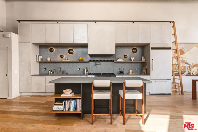 a living room with stainless steel appliances kitchen island granite countertop furniture and a fireplace