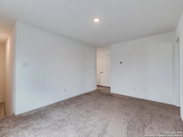 a bedroom with a bed a dresser and a lamp