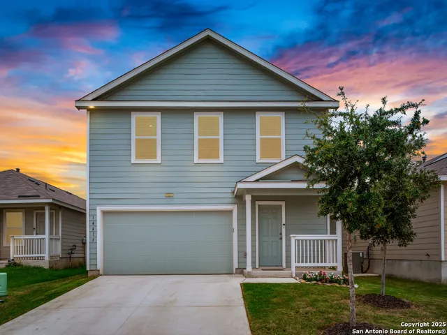 a front view of a house with a garden and yard