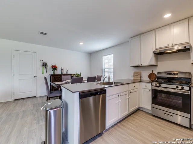 a kitchen with stainless steel appliances granite countertop a stove and a sink