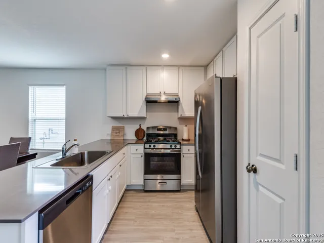 a kitchen with a sink cabinets and stainless steel appliances