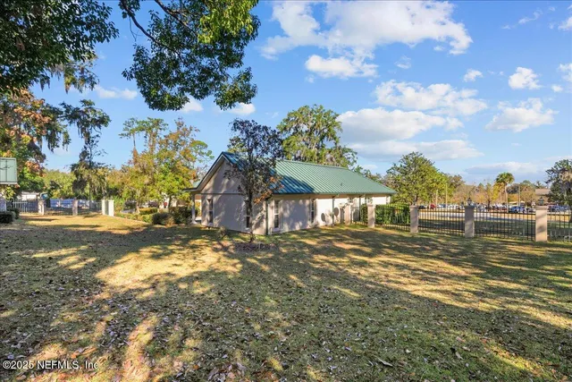 a view of a livingroom with a fireplace a chandelier and windows