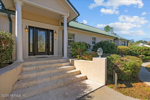 a view of a house with potted plants and a pathway