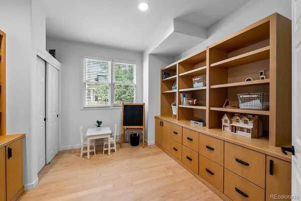 a view of a workspace with furniture and a window