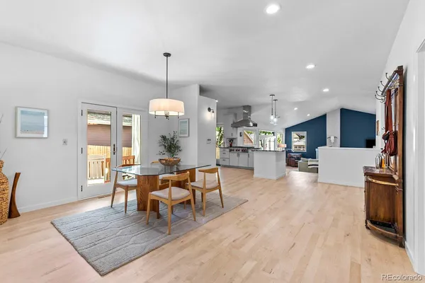 a living room with furniture dining table and a wooden floor