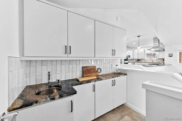a kitchen with white cabinets sink and white appliances