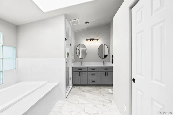 a bathroom with a tub sink and mirror