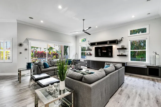 a living room with furniture a flat screen tv and a large window