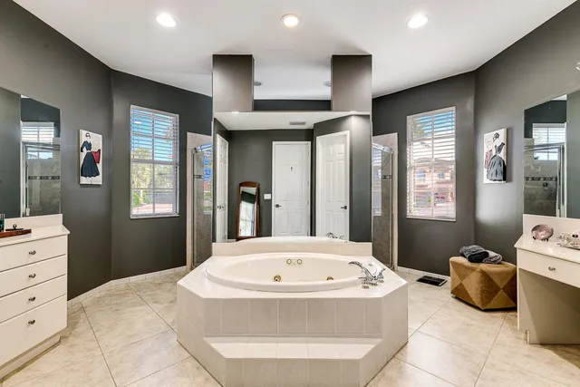 a spacious bedroom with a bed and a dresser