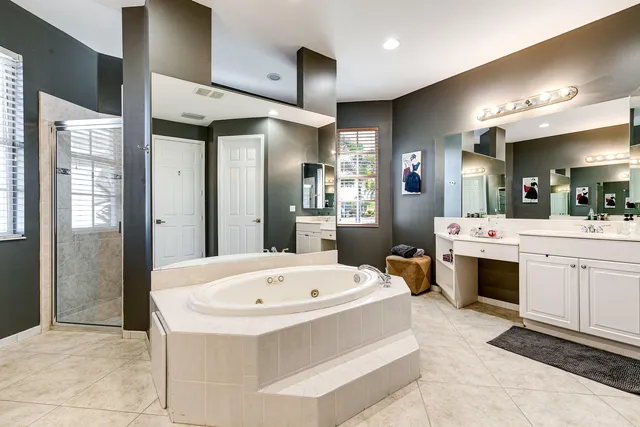 a bathroom with a tub sink and mirror